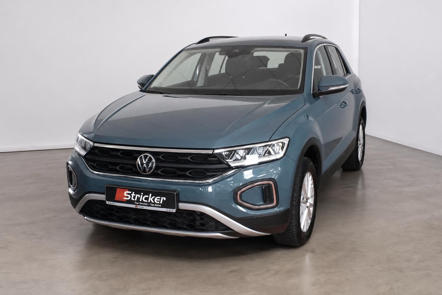 VW T-Roc in Blau, Frontansicht schraeg im Showroom
