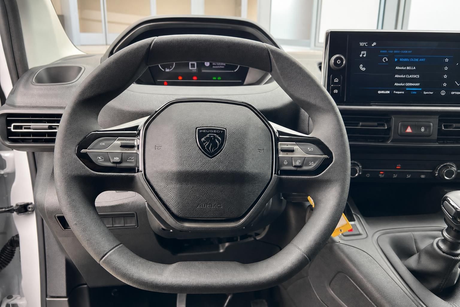 Lenkrad mit Peugeot Logo und Multifunktionstasten im Fahrzeuginnenraum