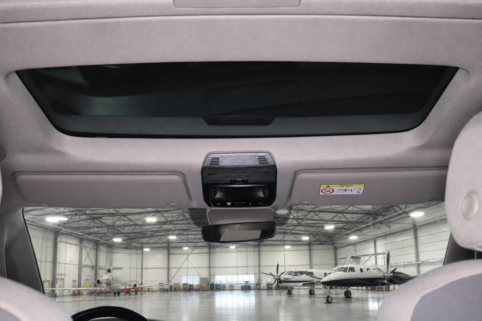 Innenraum VW Bus Blick durch Panoramadach mit Rueckspiegel und Flugzeughangar