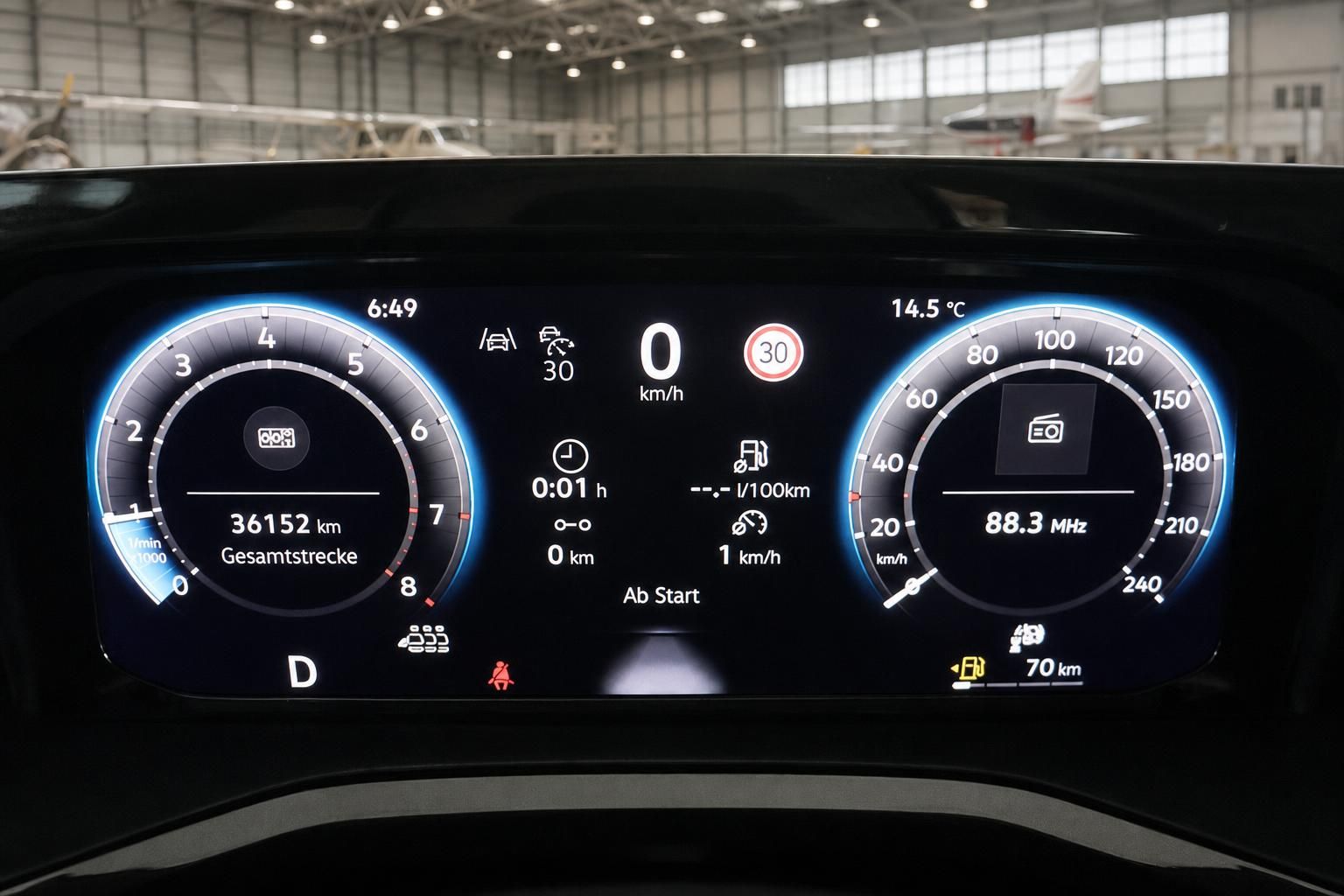 Digitales Cockpit VW mit Tacho und Fahrzeuginformationen im Hangar