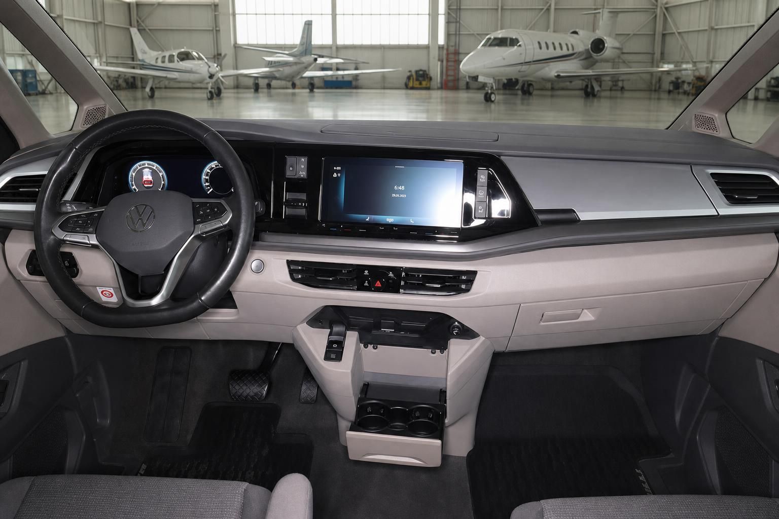 VW Cockpit Innenraum mit Lenkrad und Armaturenbrett vor Flugzeughangar