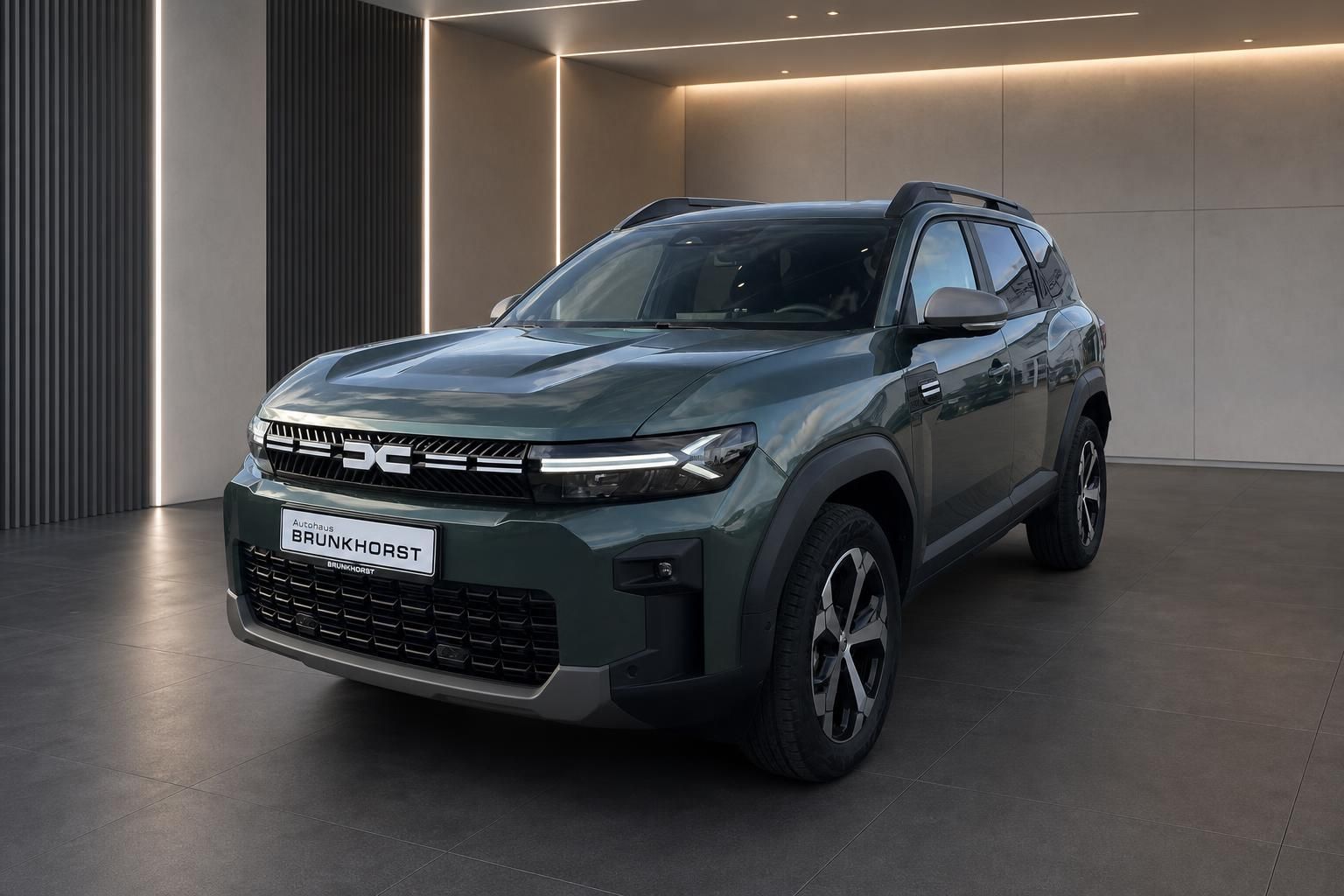 Dacia SUV Frontansicht schräg in grün im Autohaus Showroom