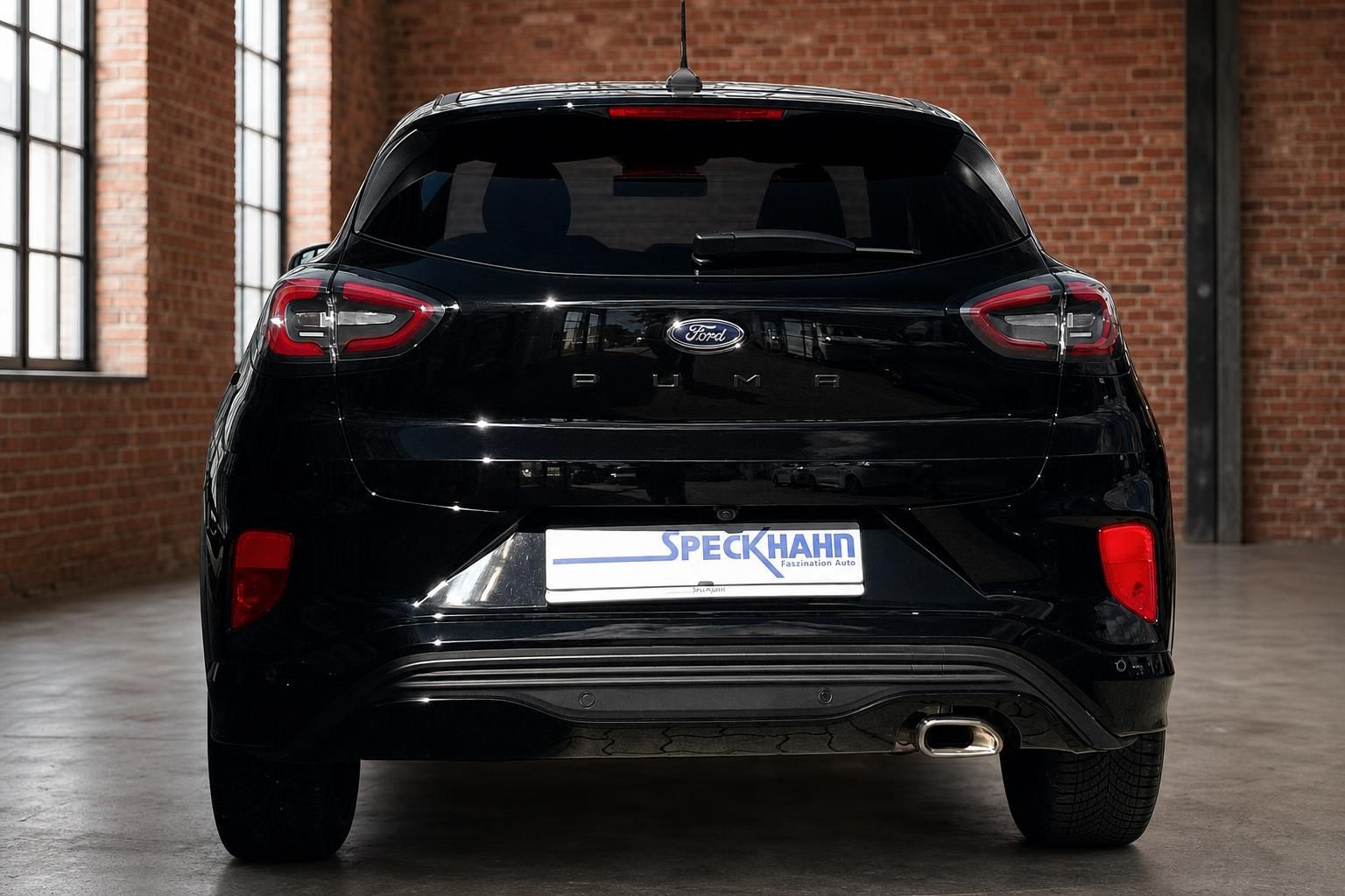 Ford Puma schwarz Heckansicht in Industriehalle mit Backsteinwand