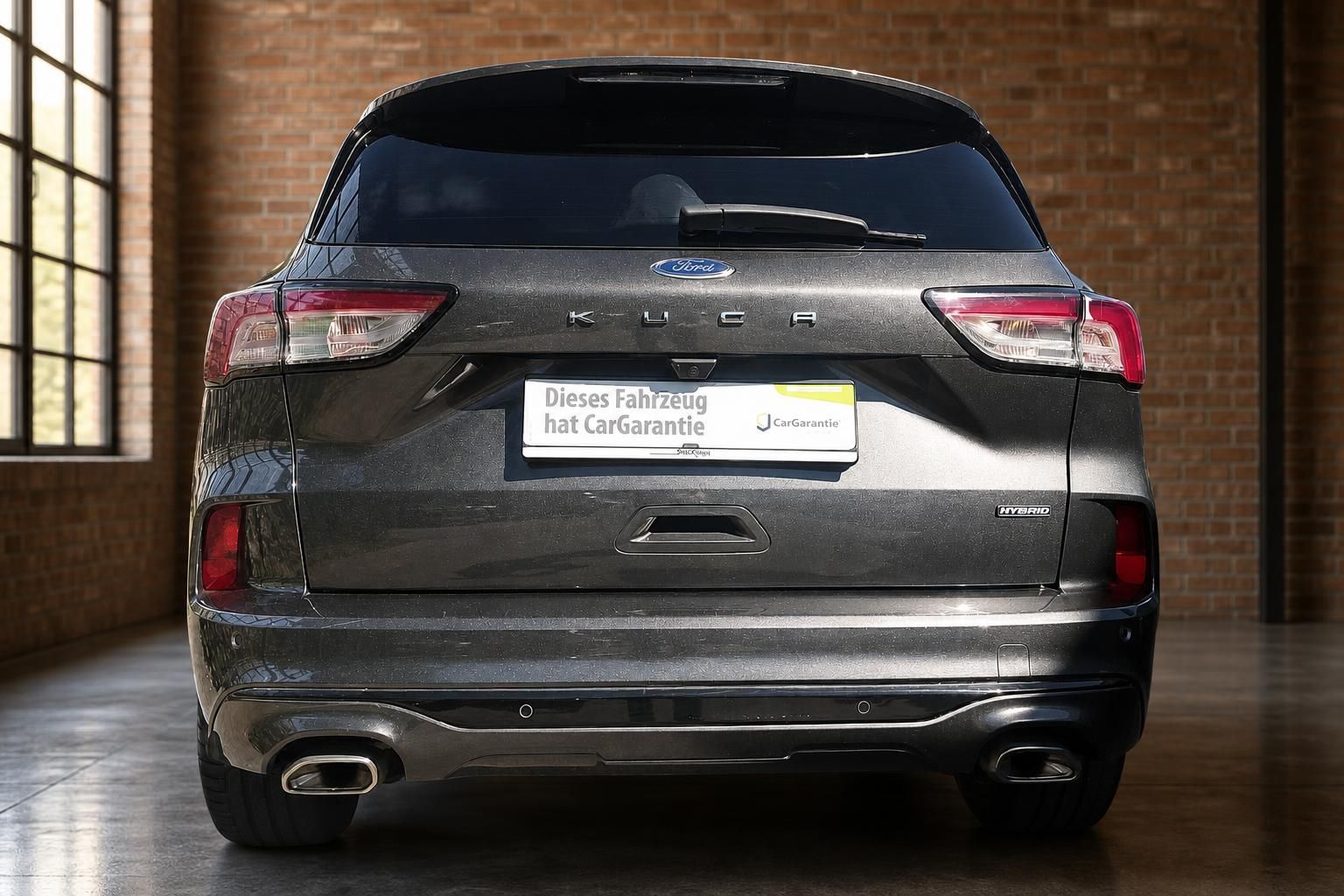 Ford Kuga Hybrid grau metallic Heckansicht gerade mit CarGarantie-Kennzeichenhalter