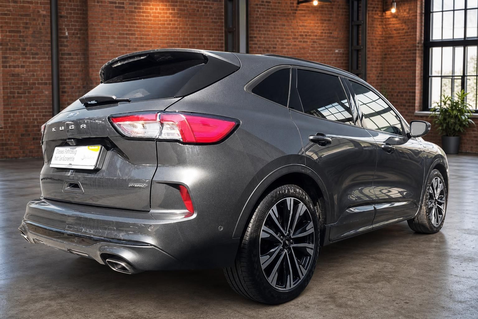 Ford Kuga Hybrid grau metallic Heckansicht schräg rechts mit CarGarantie-Kennzeichenhalter