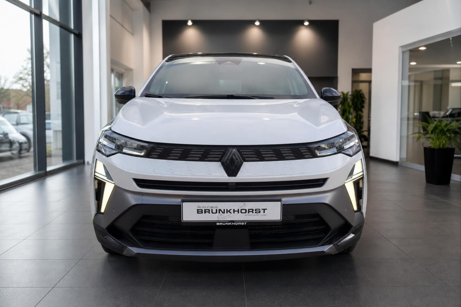 Renault Elektrofahrzeug Frontansicht - weißer SUV mit LED-Scheinwerfern im Showroom