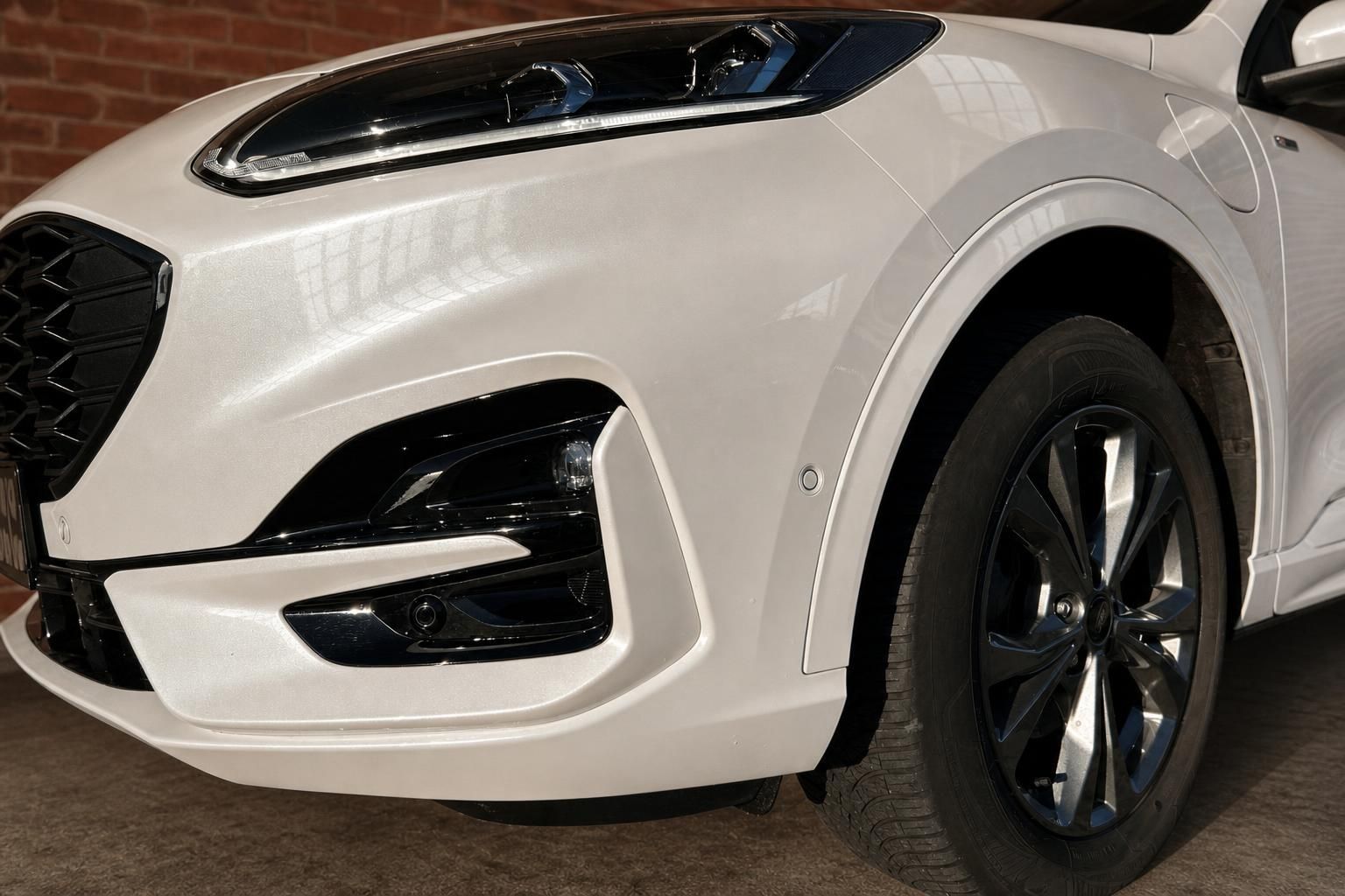 Ford Kuga weiß, Detailansicht Frontstoßstange und Felge