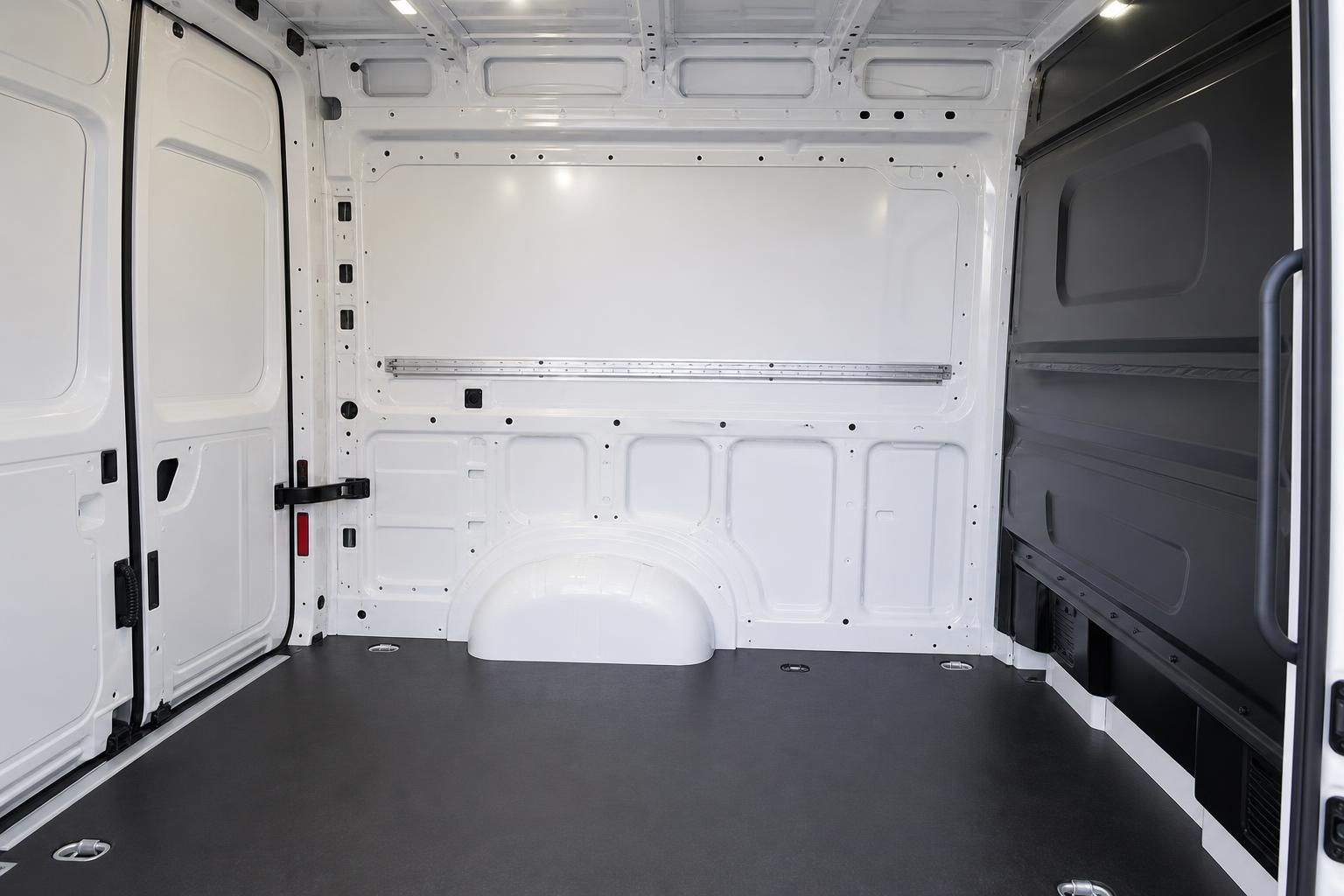 Leerer Laderaum eines weißen Transporters mit Ladeschienen und Rückwand