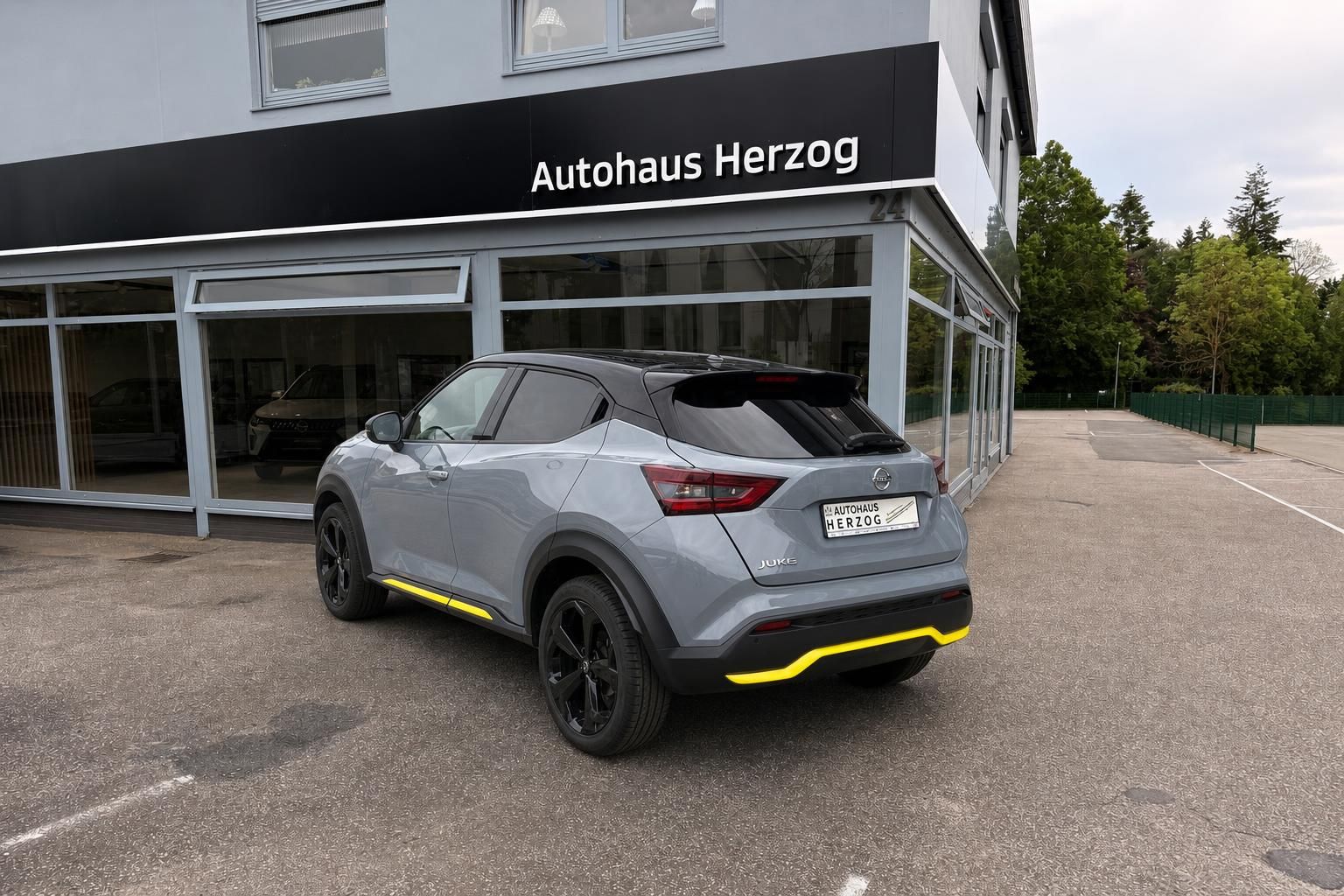 Nissan Juke grau metallic Heck-Seitenansicht mit schwarzen Alufelgen und Spoiler