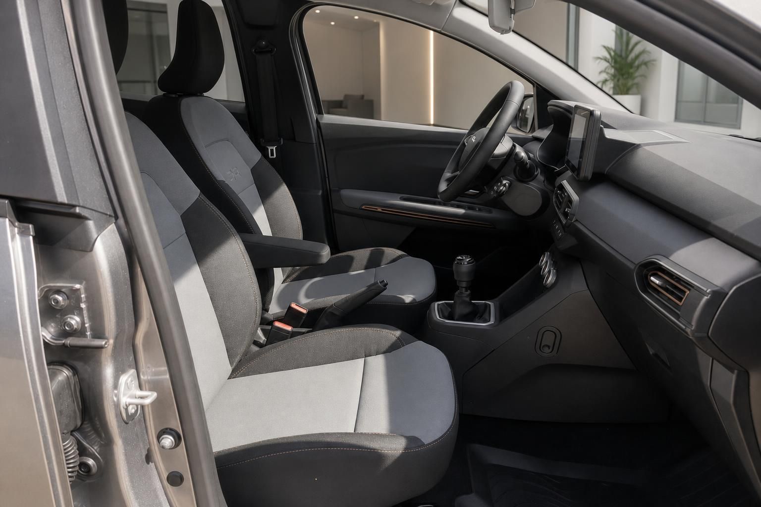 Dacia Fahrzeug Innenraum Vordersitze mit grauer Polsterung und Schaltgetriebe im Cockpit