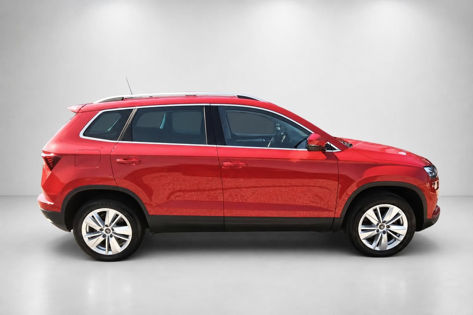Roter Skoda Karoq, Seitenprofil vor grauem Hintergrund