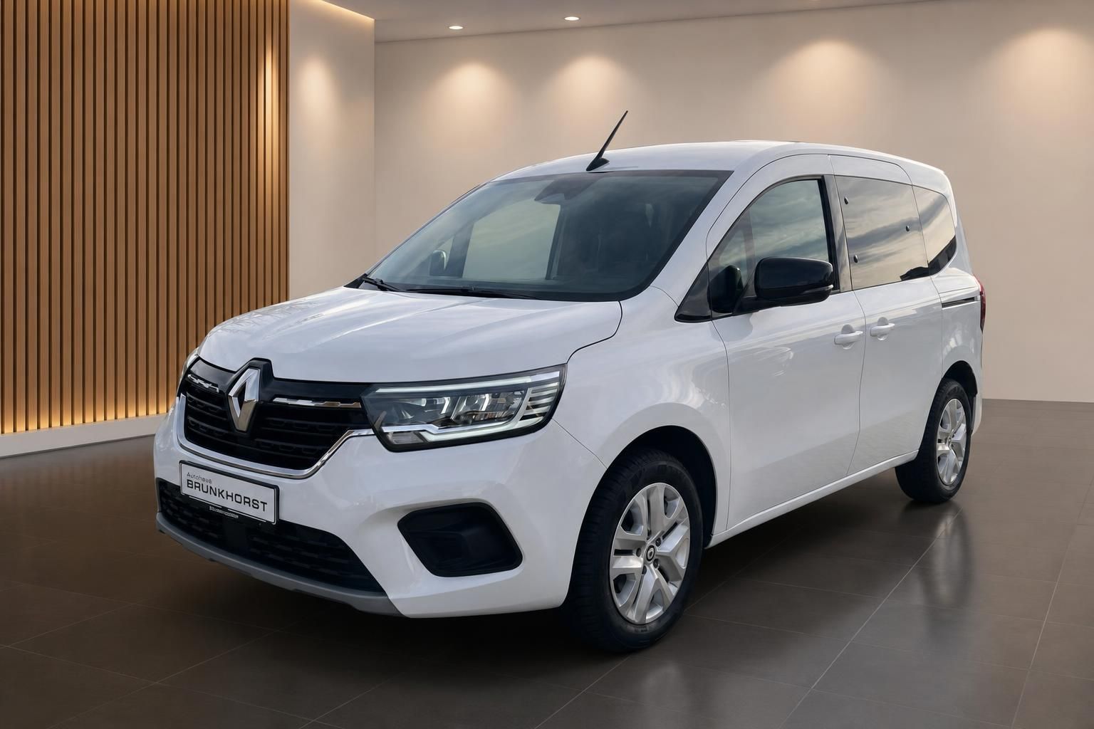 Weißer Renault Van im modernen Autohaus-Showroom, Seitenansicht mit Holzverkleidung im Hintergrund