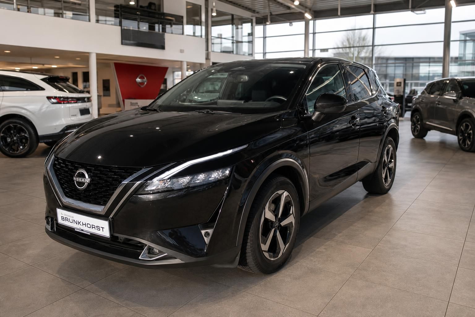 Nissan SUV schwarz Seitenansicht im modernen Autohaus Showroom