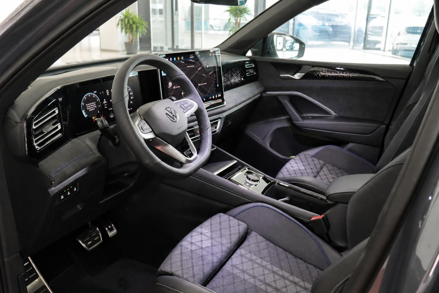 VW Innenraum mit Sportsitzen, Lenkrad und Touchscreen von vorne