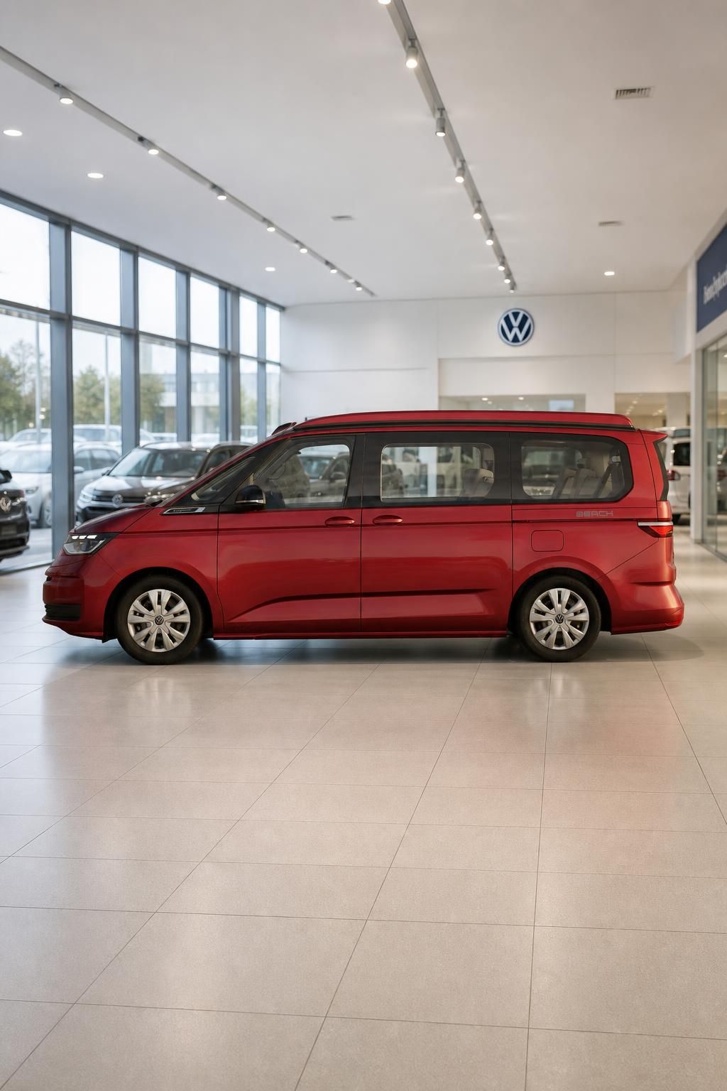 VW California Beach in Rot, Seitenansicht im Autohaus