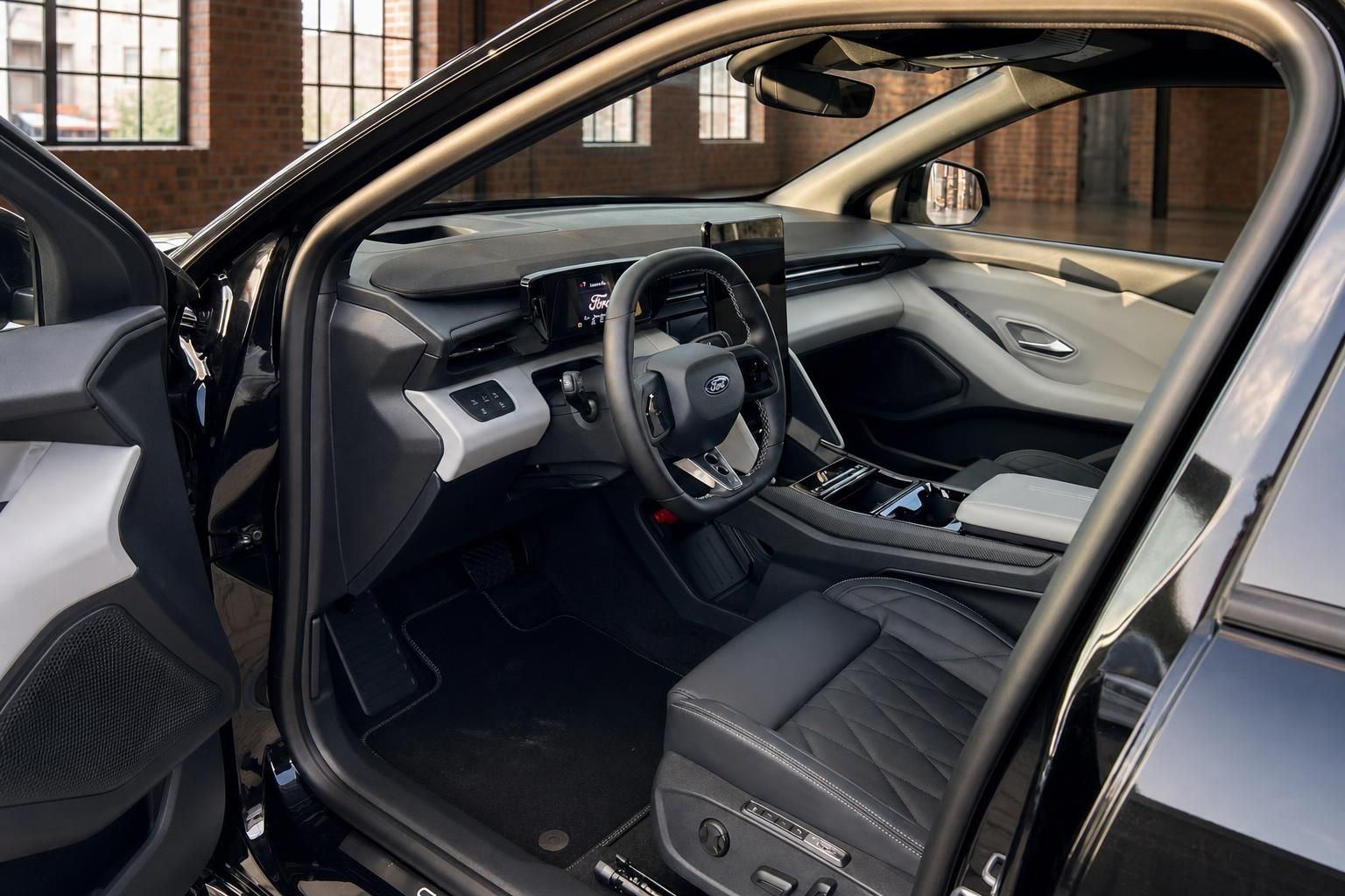 Ford Innenraum Fahrerseite mit Lenkrad, Touchscreen und schwarzen Ledersitzen