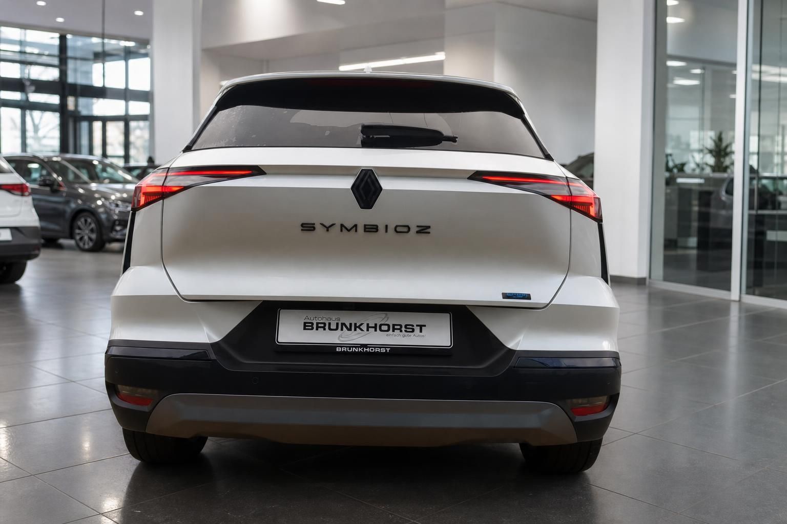 Renault Symbioz Heckansicht in weiß im Autohaus Showroom - Elektro-SUV mit LED-Rückleuchten