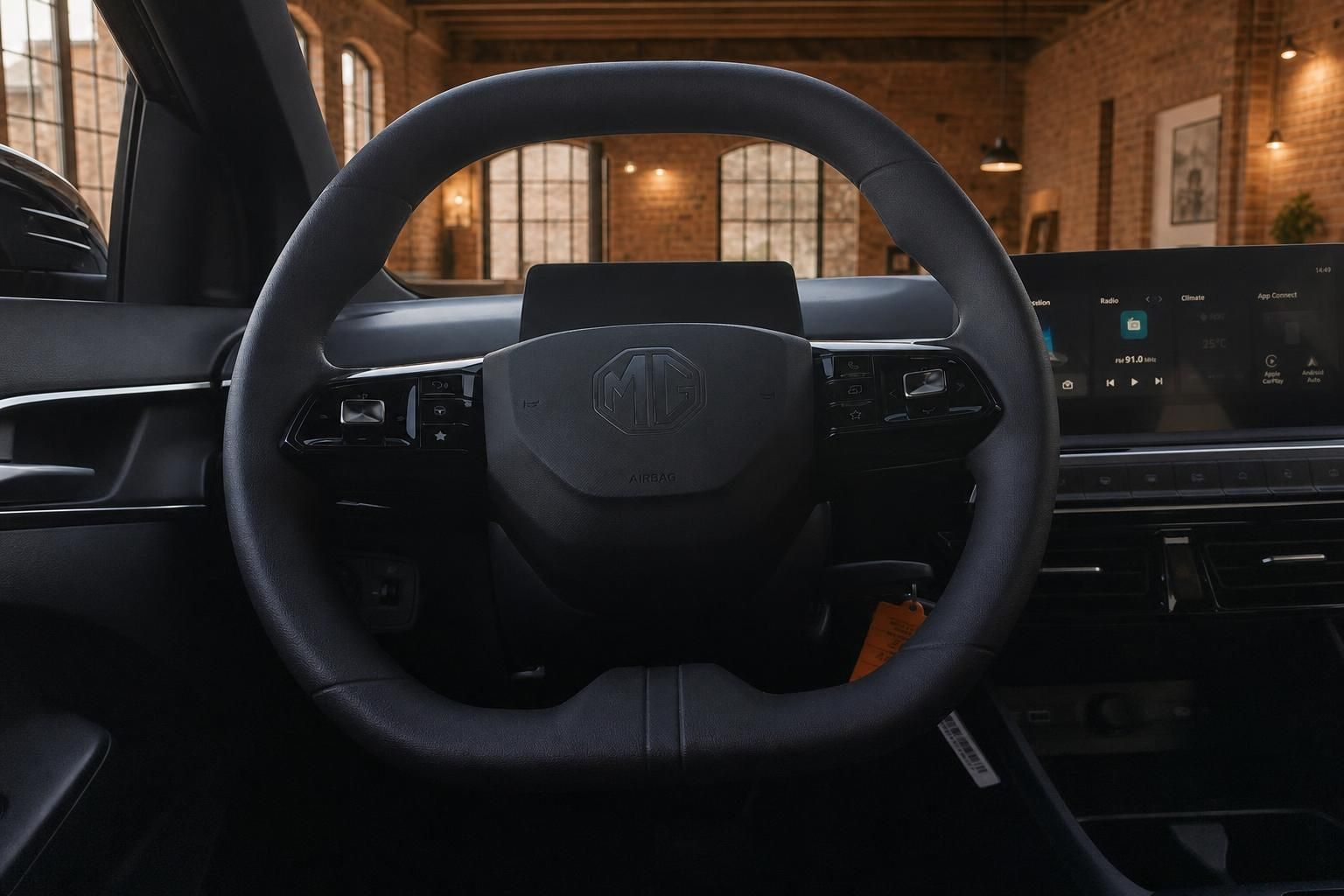 Lenkrad mit MG-Logo und Blick auf Cockpit sowie Infotainmentbildschirm