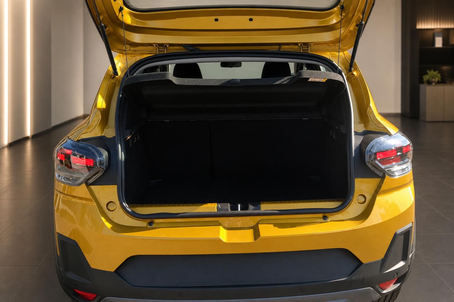 Gelbes Fahrzeug von hinten mit geöffneter Heckklappe und großem Kofferraum im Autohaus