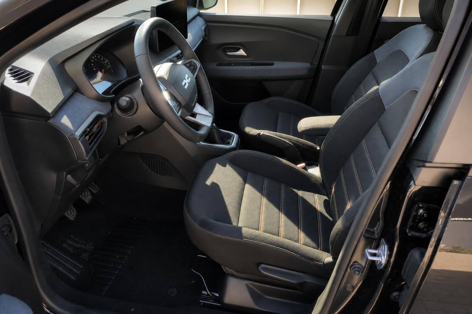 Dacia Sandero Innenraum mit dunklen Sitzen und Lenkrad