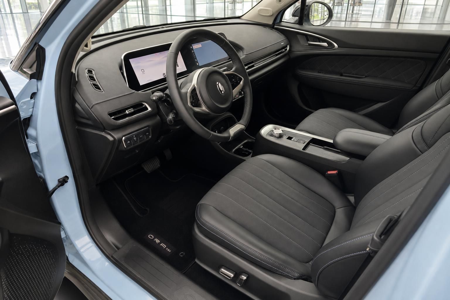 ORA Elektroauto Innenraum mit schwarzen Ledersitzen, Lenkrad und Infotainment-Display