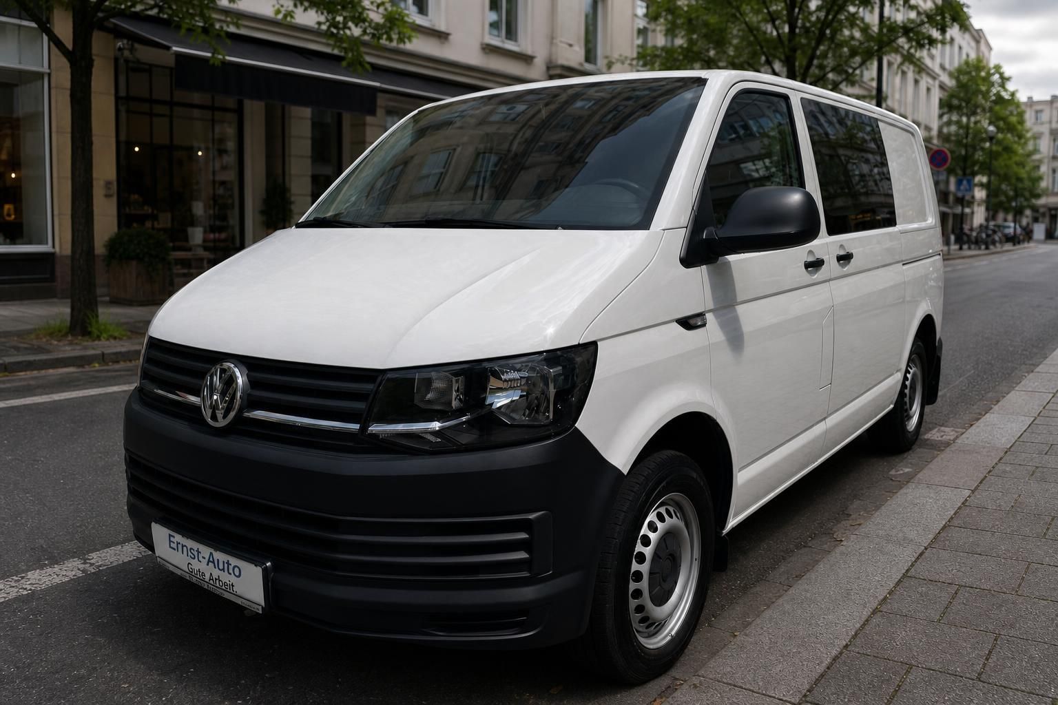 Volkswagen Transporter T6 weiss Frontansicht mit dunklen Scheiben und Haendlerkennzeichen