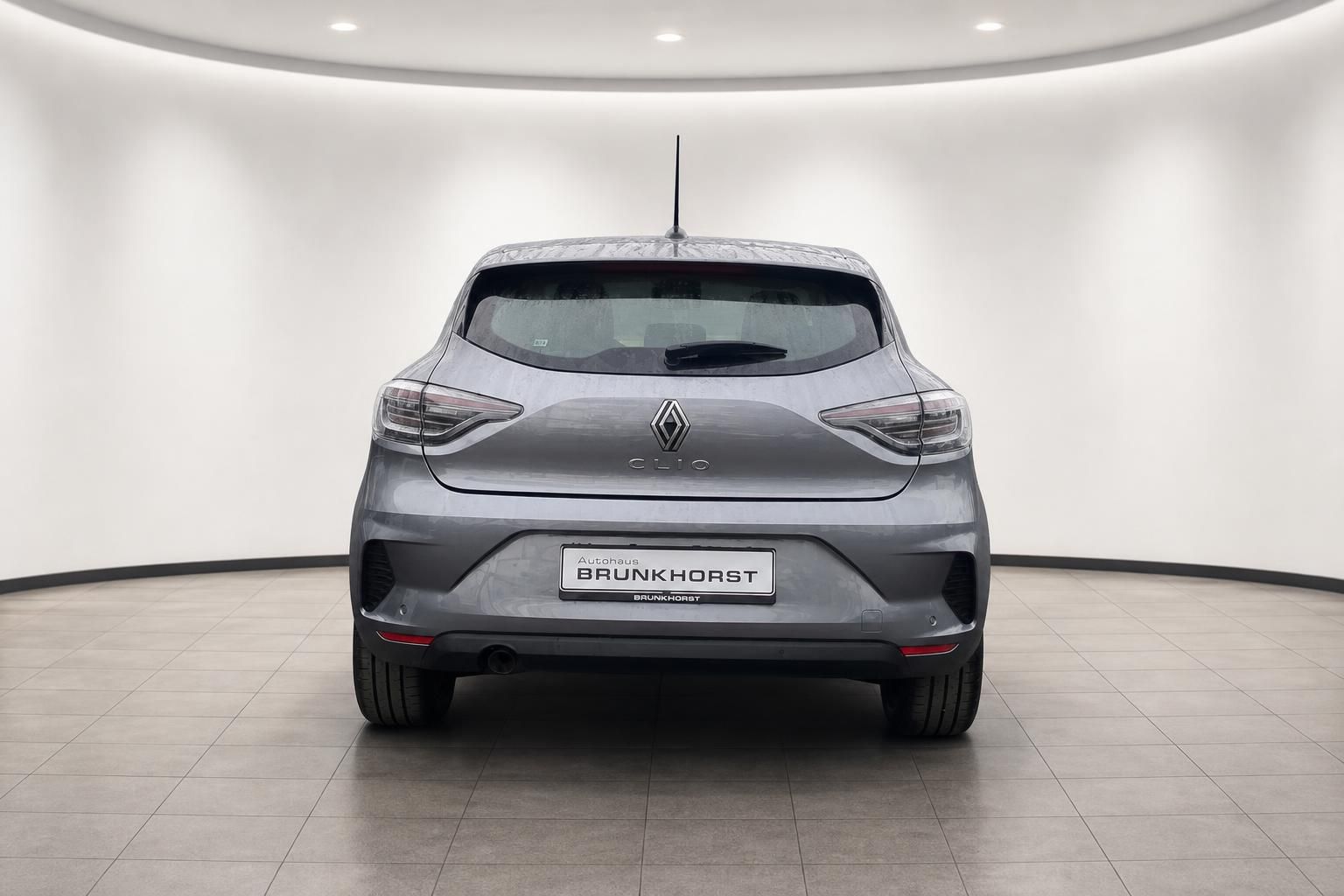 Grauer Renault Clio Heckansicht in weißem Showroom mit Brunkhorst Händlerkennzeichen