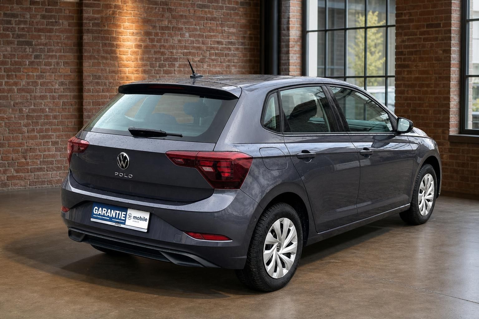 VW Polo grau Heckansicht seitlich in Industrie-Loft