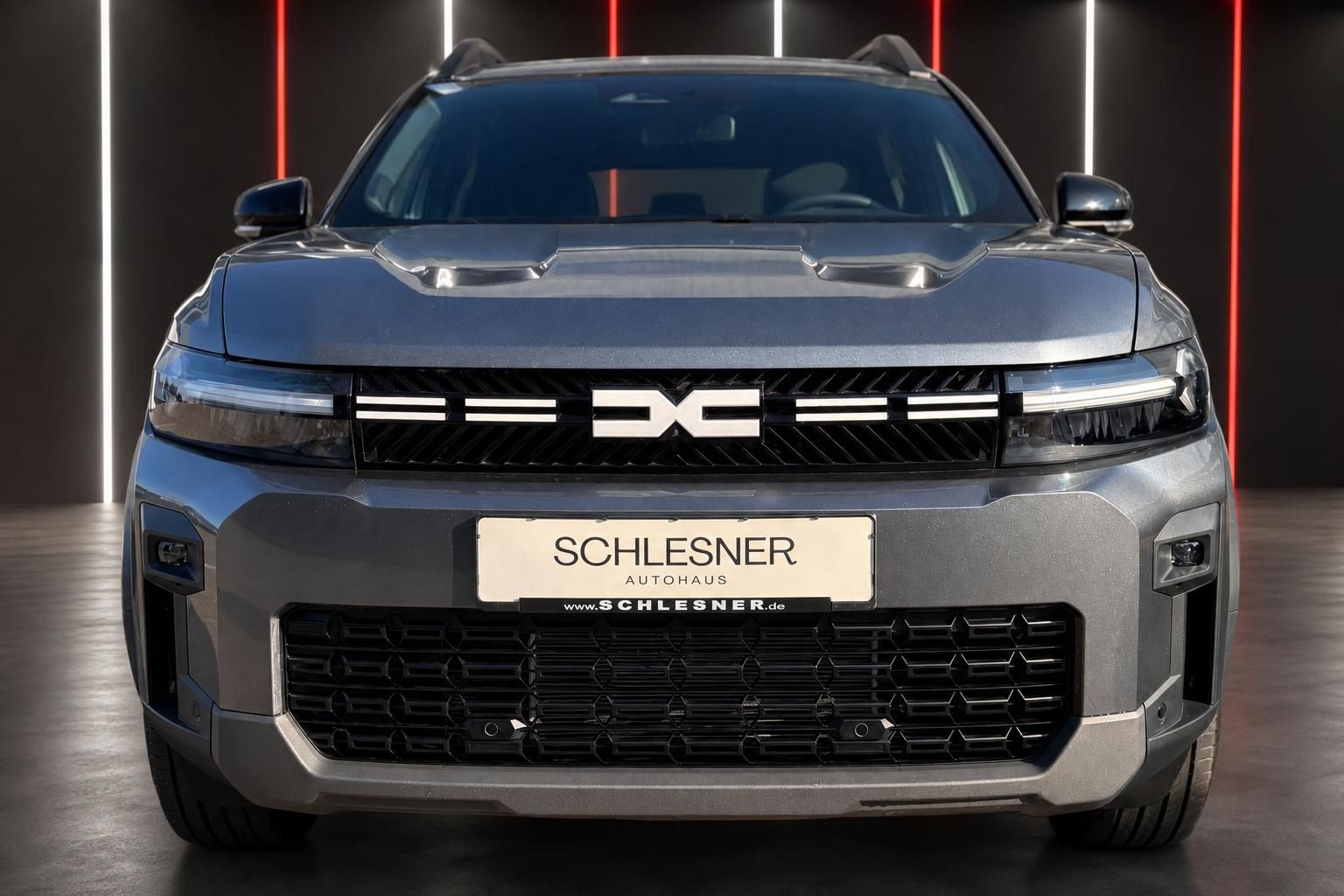 Dacia SUV grau Frontansicht mit Kuehlergrill und Kennzeichenhalter