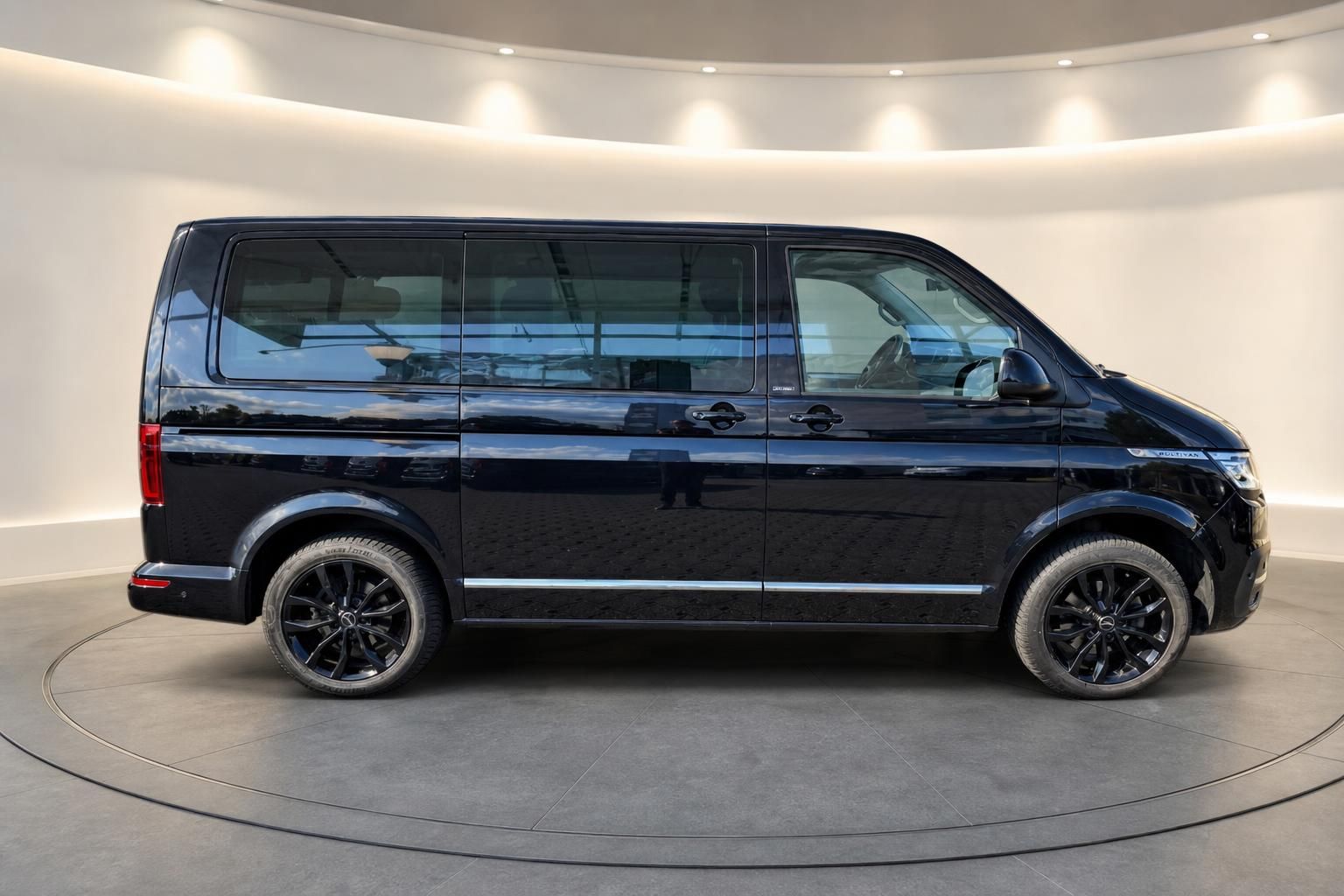 VW Multivan schwarz Seitenansicht mit Alufelgen im Showroom