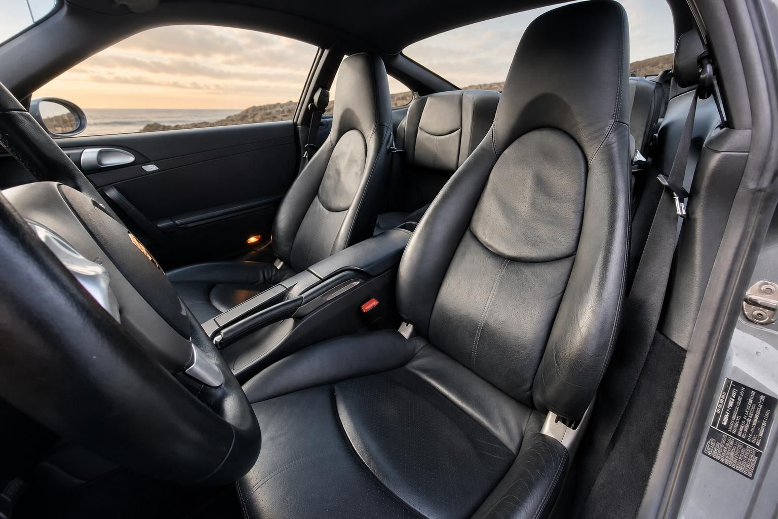 Porsche Innenraum schwarz - Fahrersitze aus Leder mit Sportausstattung und Meeresblick