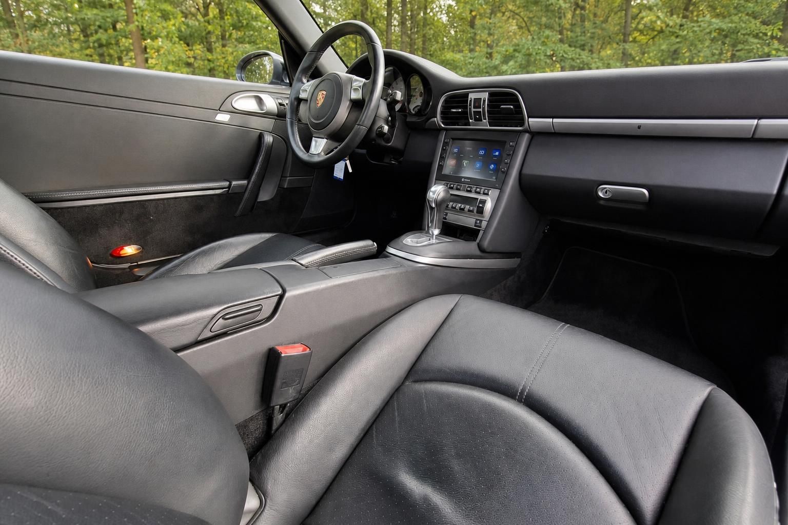 Porsche Cockpit schwarz - Armaturenbrett mit Lenkrad, Mittelkonsole und modernem Display