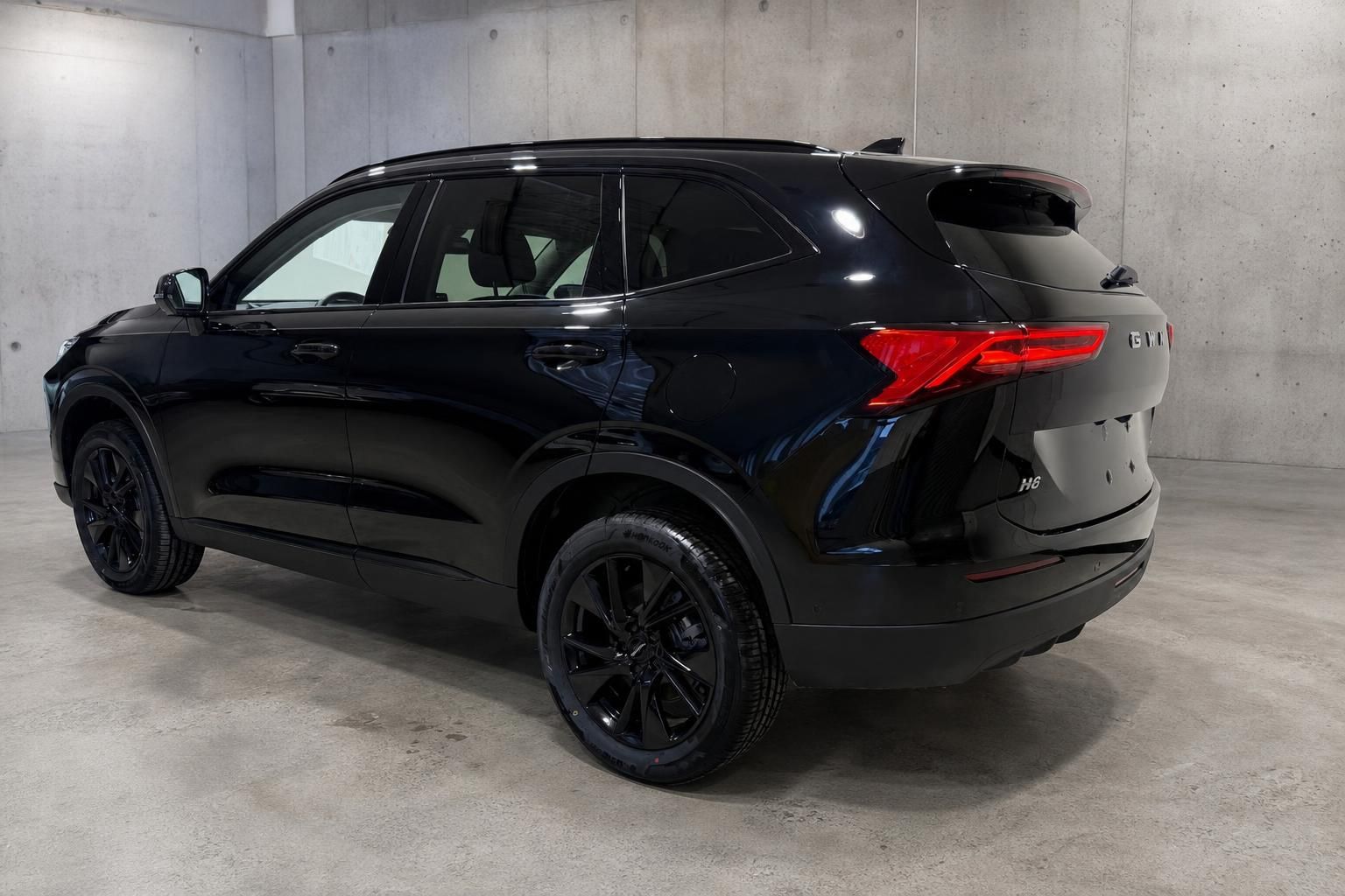 GWM H6 SUV schwarz, Heckansicht schraeg in Tiefgarage