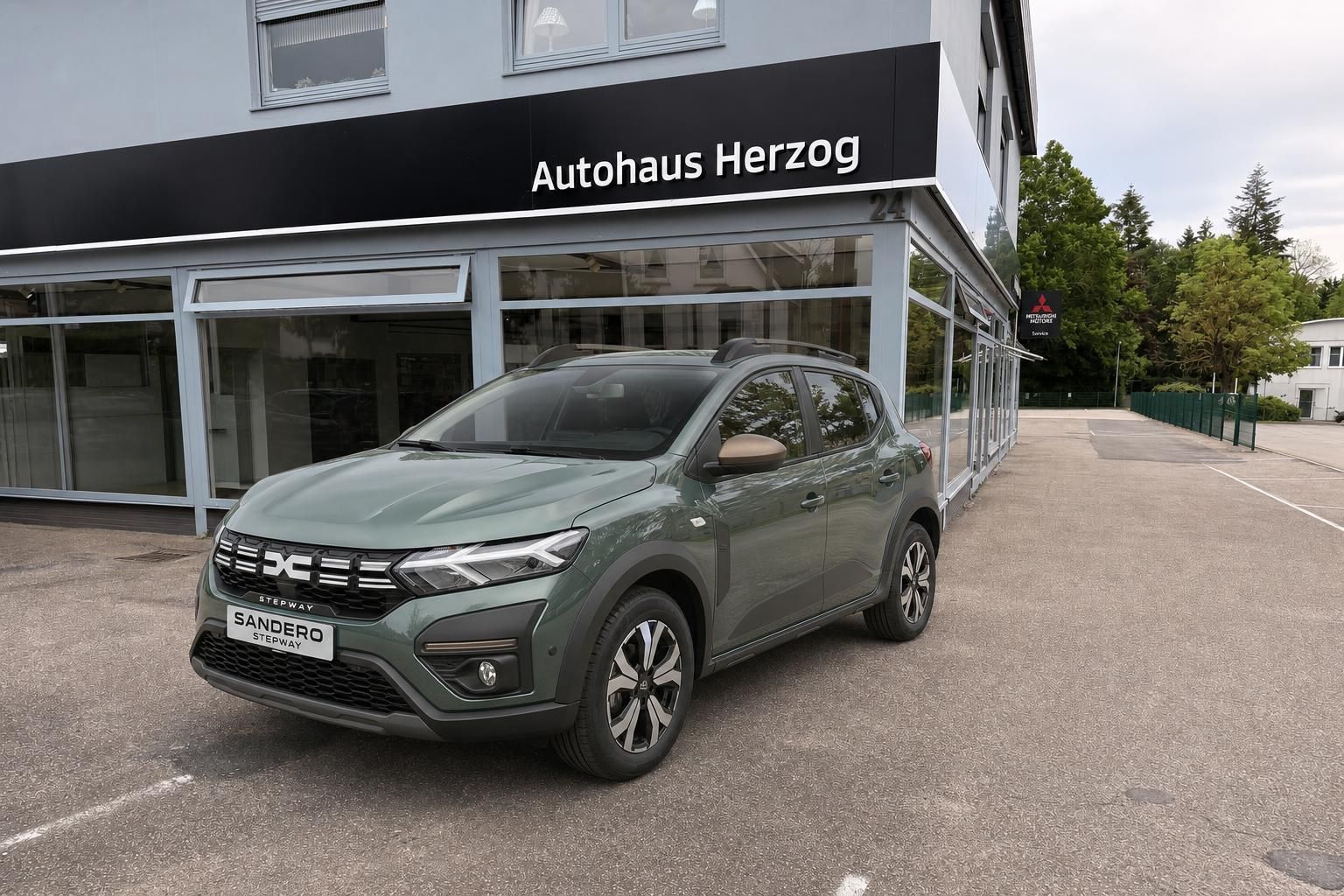 Dacia Sandero Stepway in grün vor Autohaus Herzog Ausstellungsraum