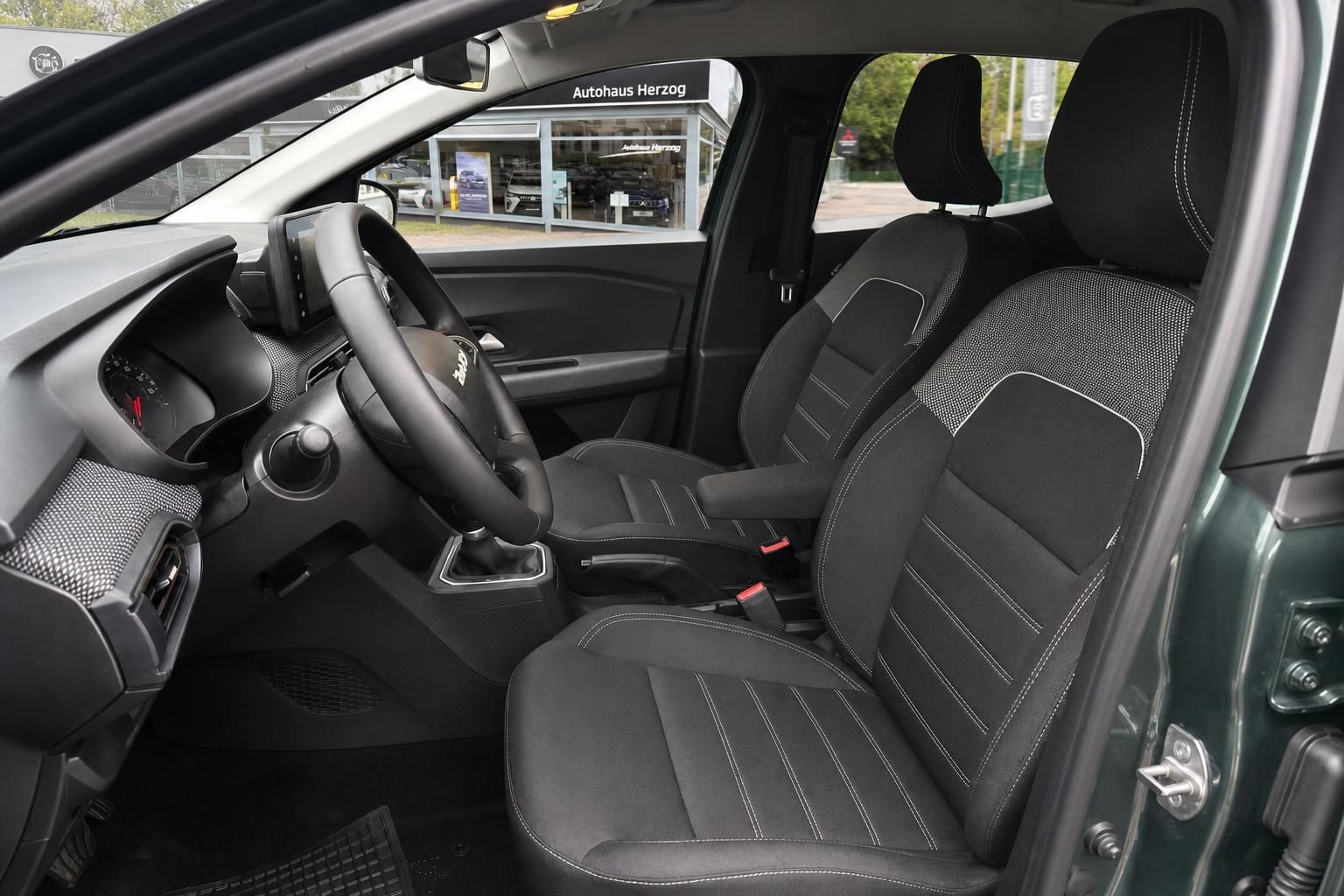 Dacia Stepway Innenraum Fahrersicht - schwarze Stoffsitze mit Schaltgetriebe und modernem Design