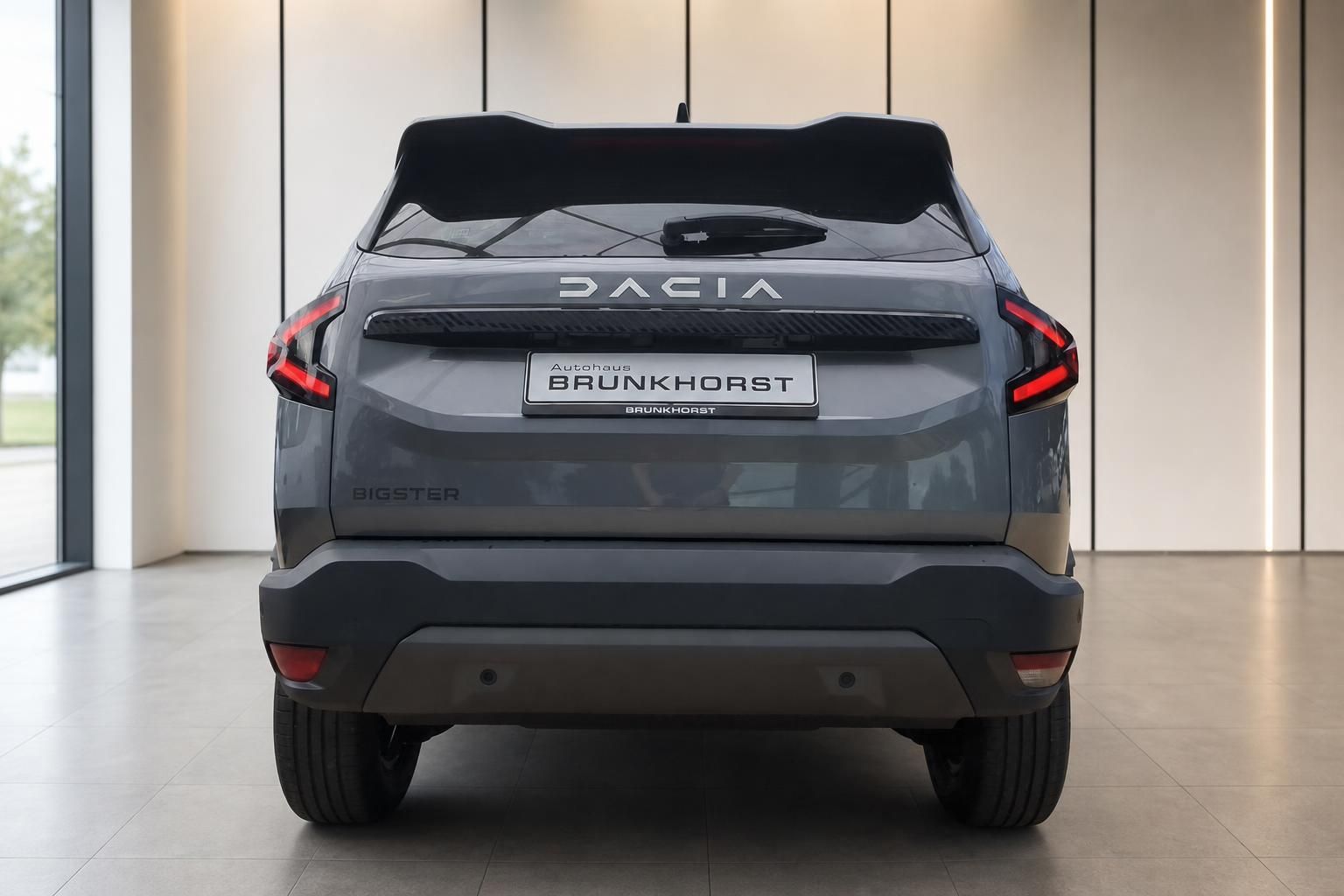 Dacia Bigster grau Heckansicht mit LED-Rueckleuchten im Showroom