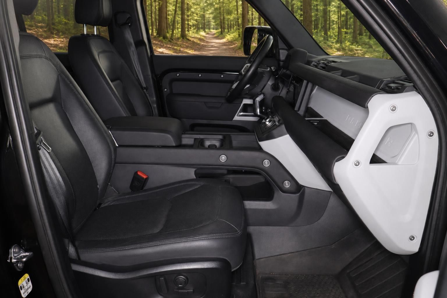 Innenraum SUV mit schwarzen Ledersitzen und weisser Tuerverkleidung im Wald