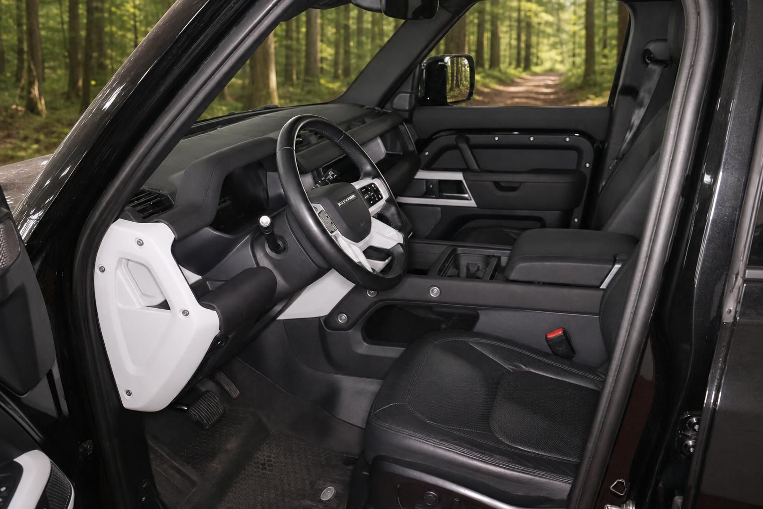 Land Rover Defender Innenraum mit Lederausstattung und weißem Türverkleidungsdesign