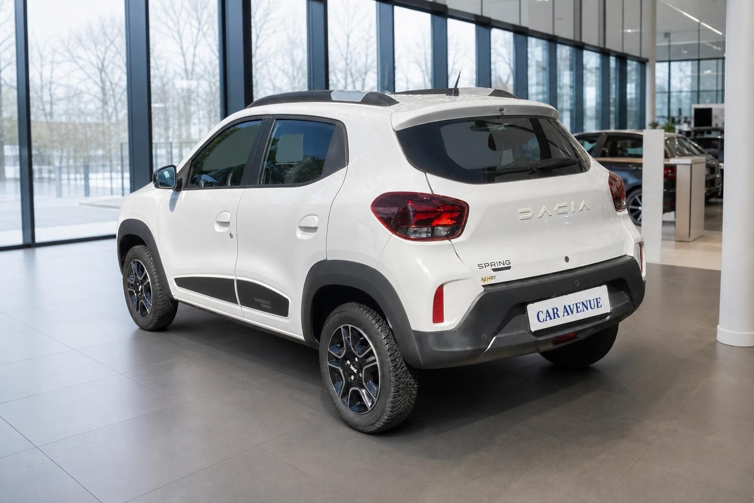 Dacia Spring weiß in Heckansicht im Autohaus Showroom