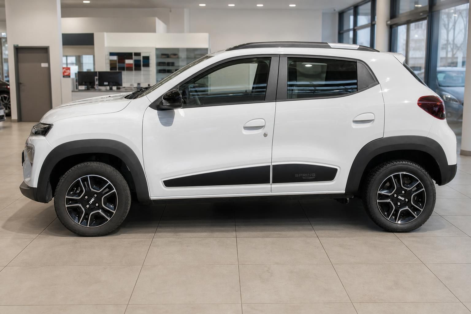 Dacia Spring weiß Seitenansicht im Autohaus Showroom