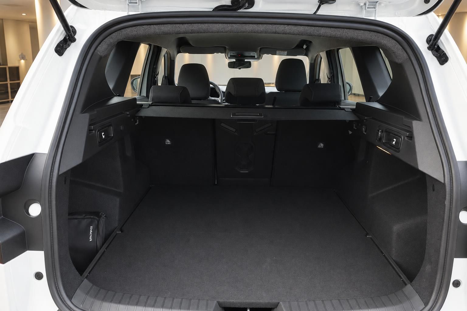 Dacia SUV Kofferraum offen – geräumiger Laderaum mit umgeklappten Sitzen und Dacia-Tasche