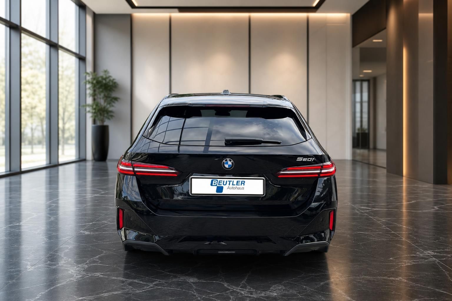 BMW 5er Touring 520i schwarz, Frontalansicht von hinten im Showroom