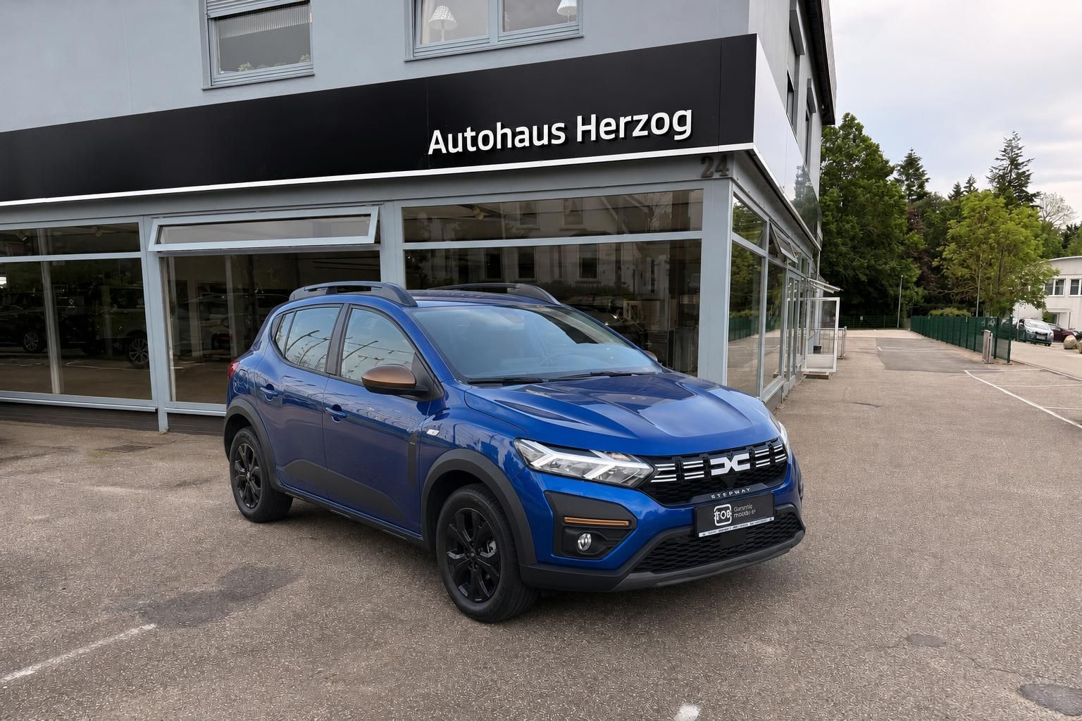 Blauer Dacia Stepway SUV Dreiviertel-Frontansicht mit schwarzen Felgen