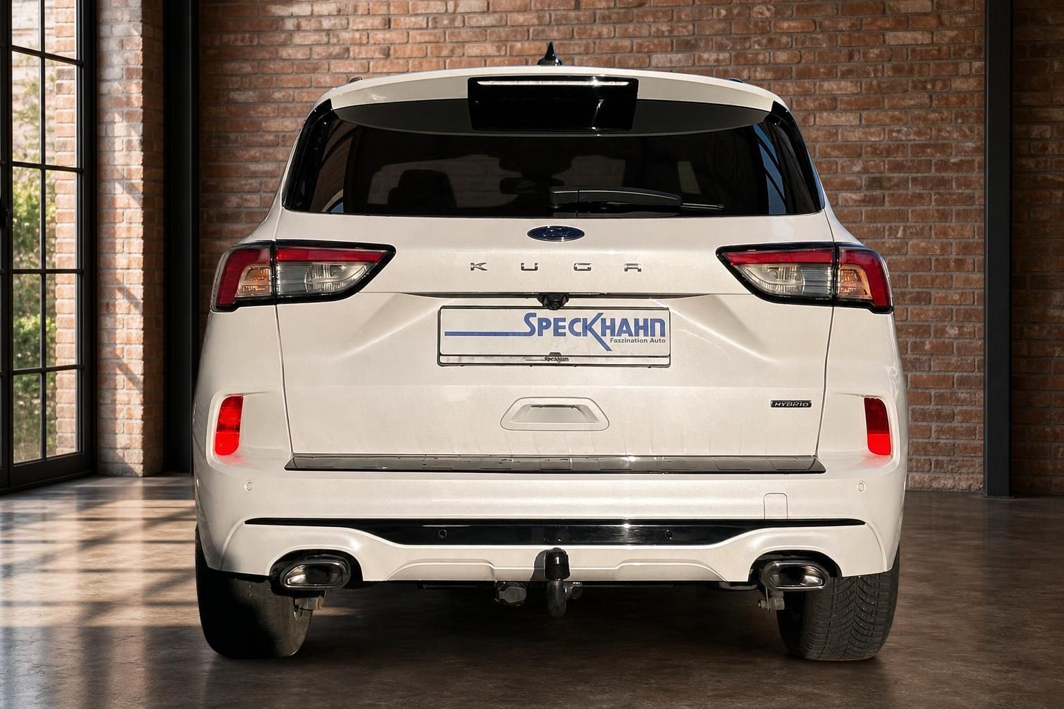 Ford Kuga Hybrid weiß, Heckansicht in Loft-Ausstellungsraum