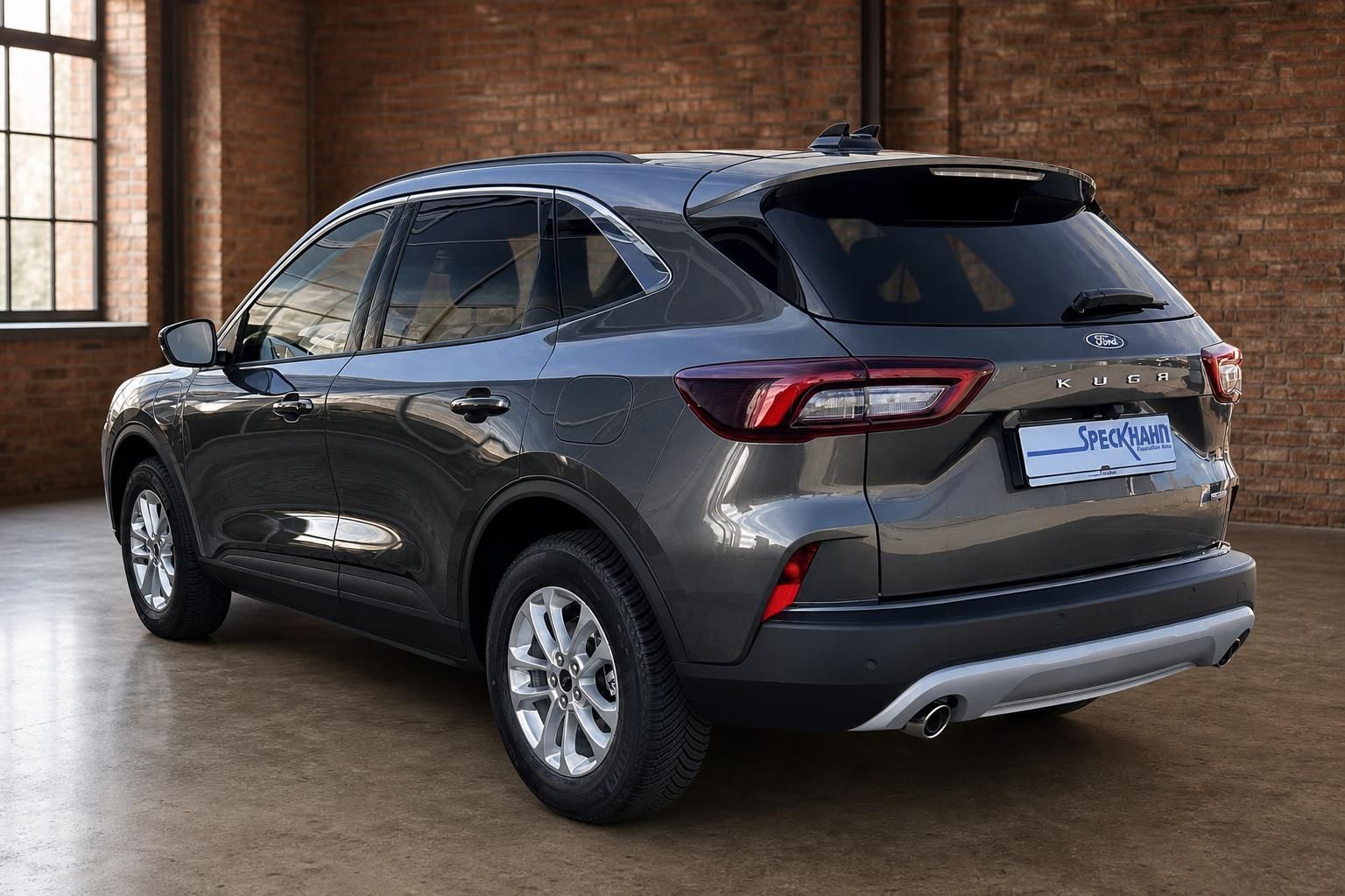 Ford Kuga Hybrid grau Heckansicht schräg links im Industrieambiente Autohaus Speckhahn