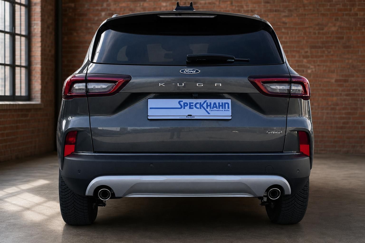 Ford Kuga Hybrid grau Heckansicht gerade mit Speckhahn Kennzeichenrahmen und Hybrid-Badge