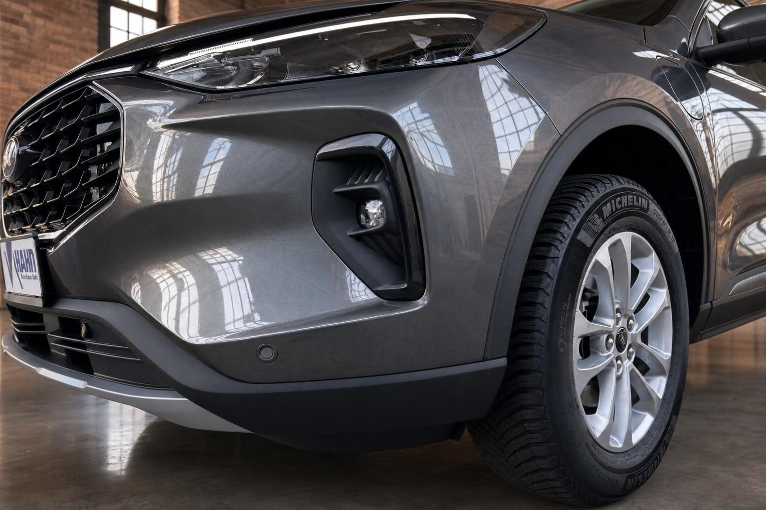 Kia SUV Frontpartie Nahaufnahme mit Nebelscheinwerfer, Kühlergrill und Michelin-Bereifung in grau