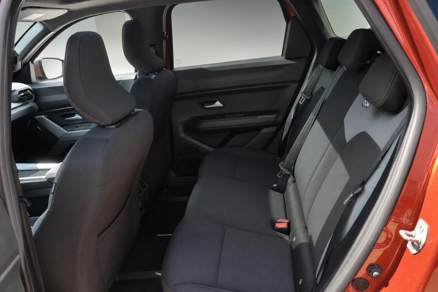 Rücksitzbank und Innenraum eines orangen SUV mit geöffneter Tür
