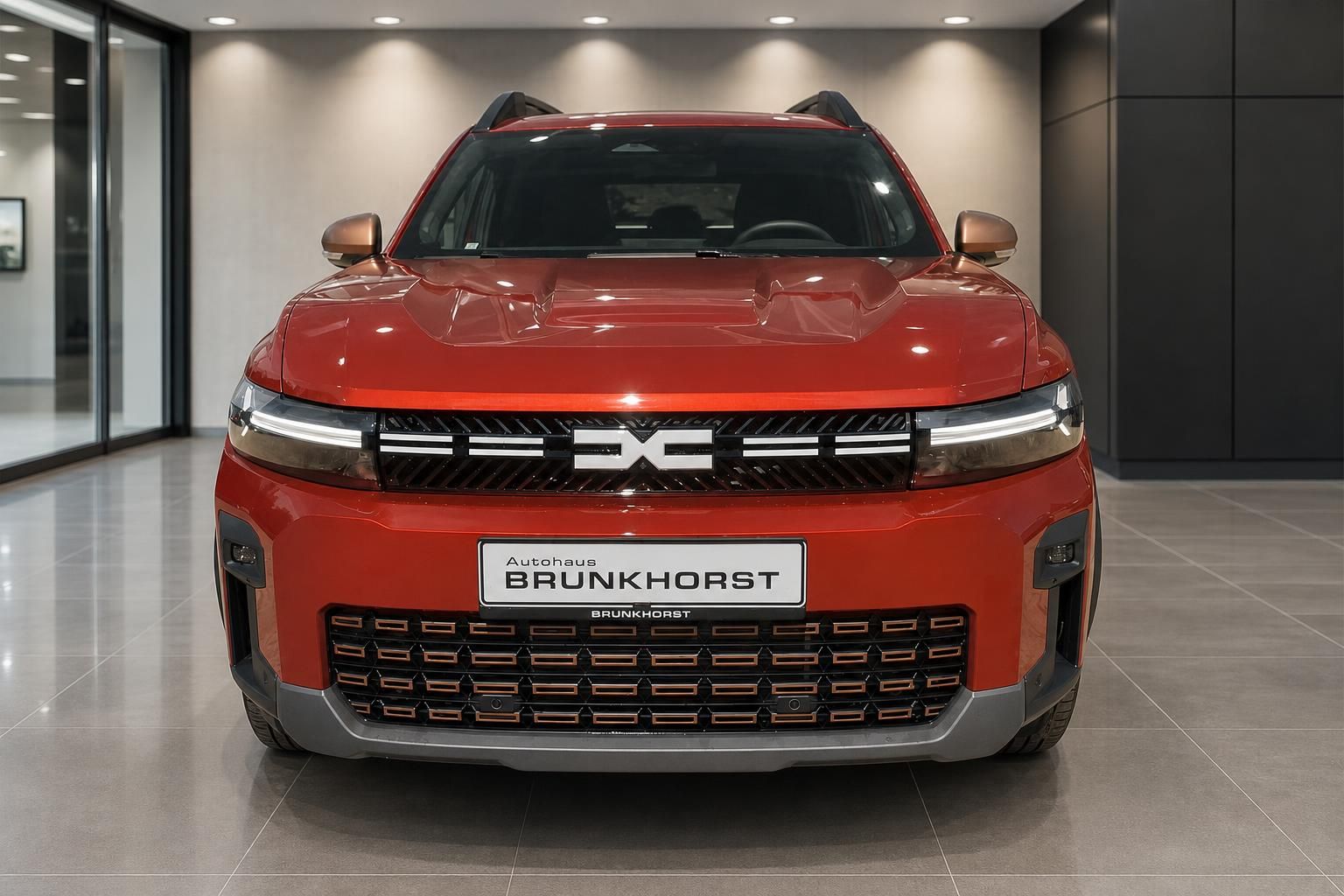Dacia Bigster Hybrid in Orange, Frontansicht im Showroom