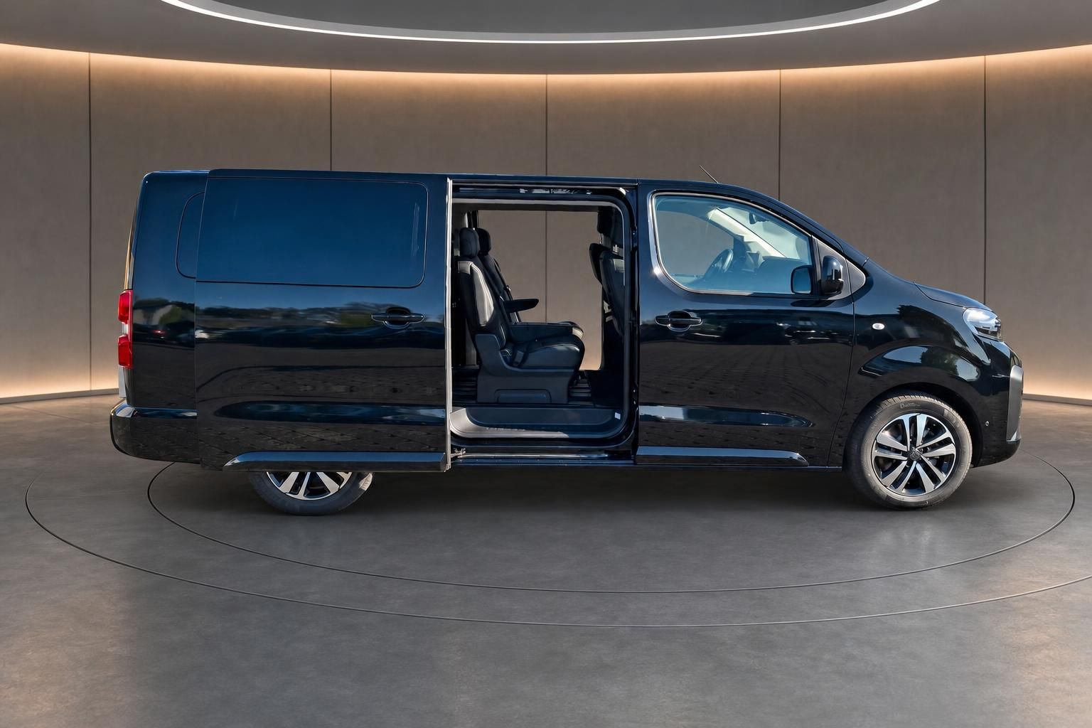 Schwarzer Peugeot Traveller Van mit offener Schiebetür zeigt geräumigen Innenraum und moderne Ausstattung